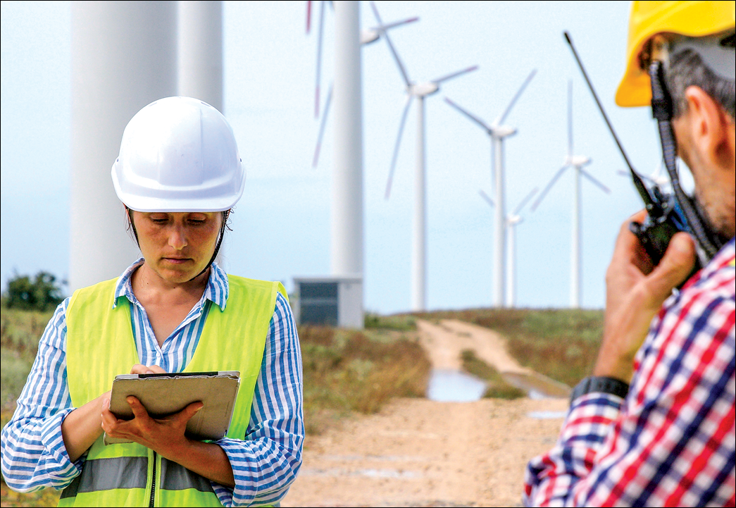 Electrical engineers team working for the energy industry, discussing the condition of the Electrical Power Equipment in a wind turbines farm power station  and checking the equipment  Business meeting of two colleagues 