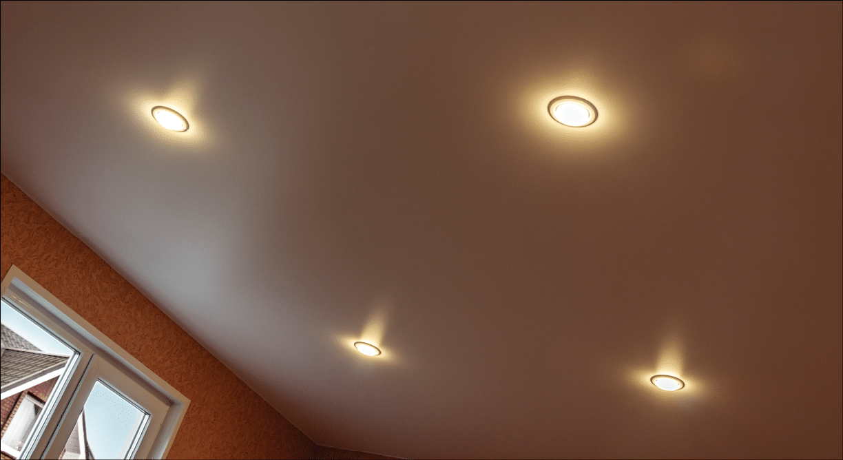 Part of the room with tension white ceiling and built-in lights 