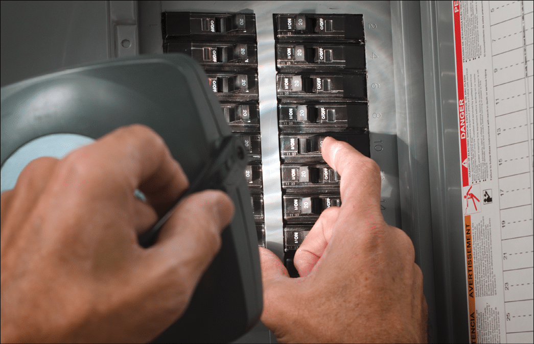 man throwing circuit breaker at residential service panel