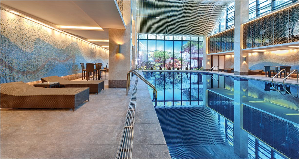 Indoor swimming pool with sun lounger on a bright day