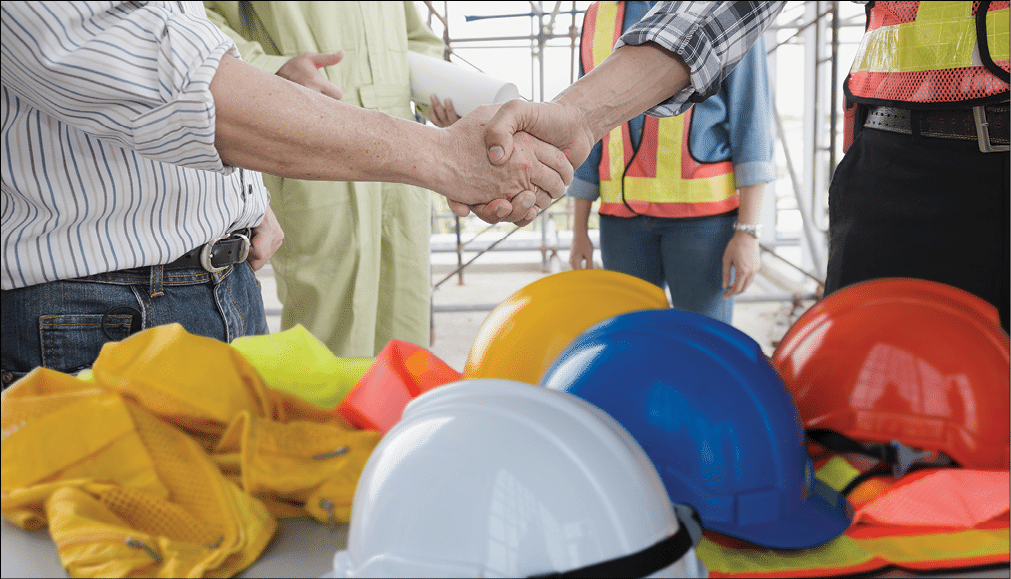 Engineer group asia handshake of congratulations with helmet on a desk  The success and safety in the workplace 