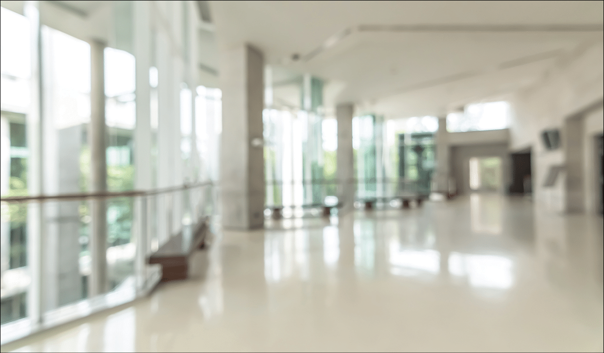 Hotel or office building lobby blur background interior view toward reception hall, modern luxury white room space with blurry corridor and building glass wall window