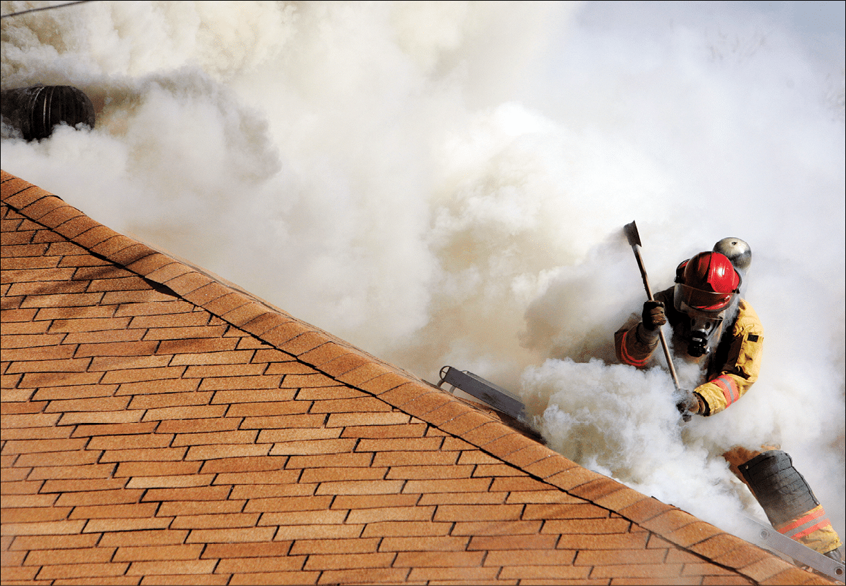 A Fire Fighter uses an axe to vent the roof of a house that is on fire   Non training event 