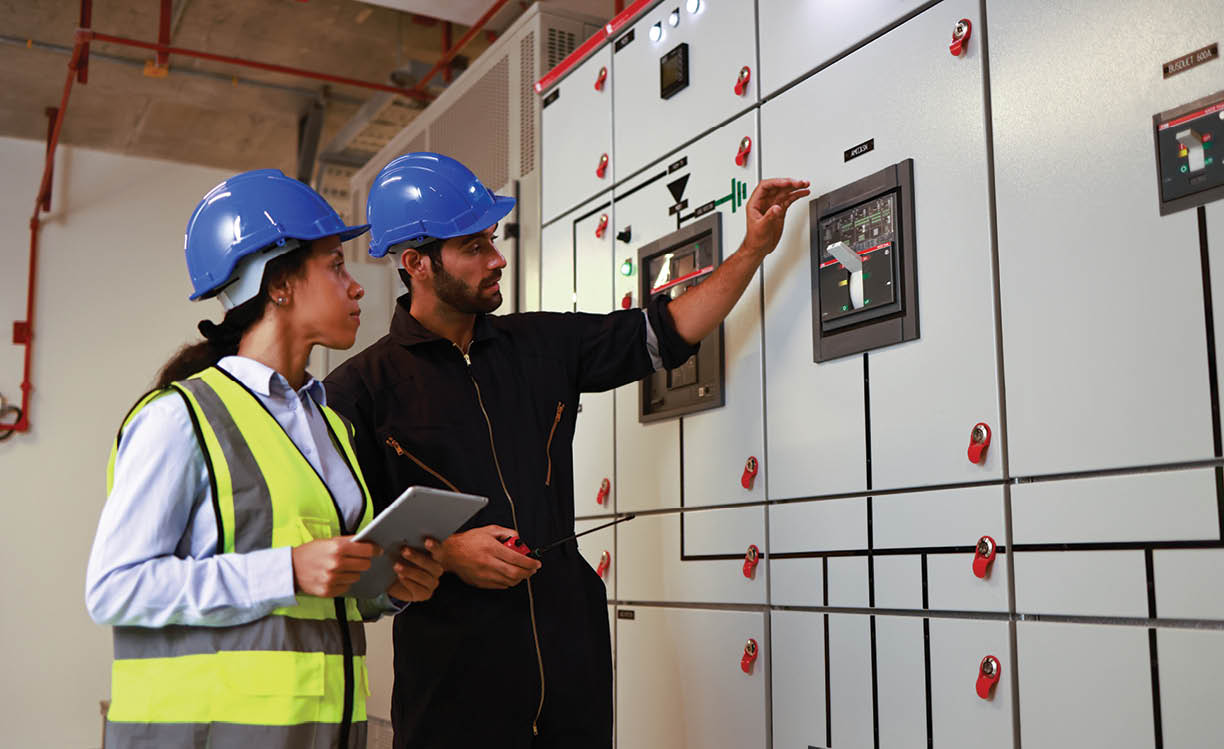 Male and Female colleague electrical engineer work checking at Electrical Distribution Control Room