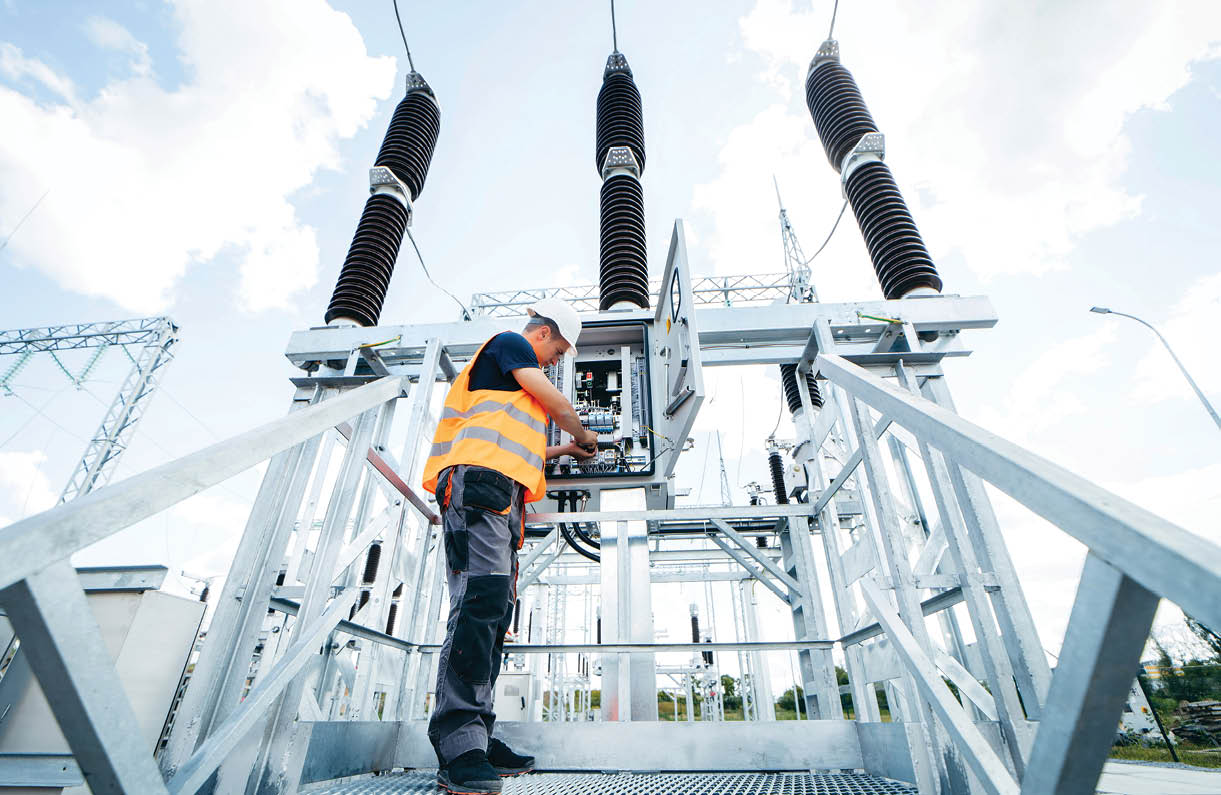 Adult electrical engineer inspect the electrical systems at the equipment control cabinet. Installation of modern electrical station