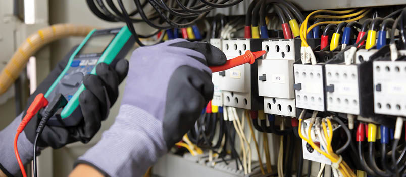 Electrician engineer tests electrical installations and wires on relay protection system. Adjustment of scheme of automation and control of electrical equipment.