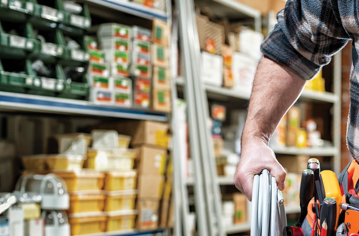 Electrician in the electrical parts store is holding the roll of electrical cable. Construction industry, electrical system.