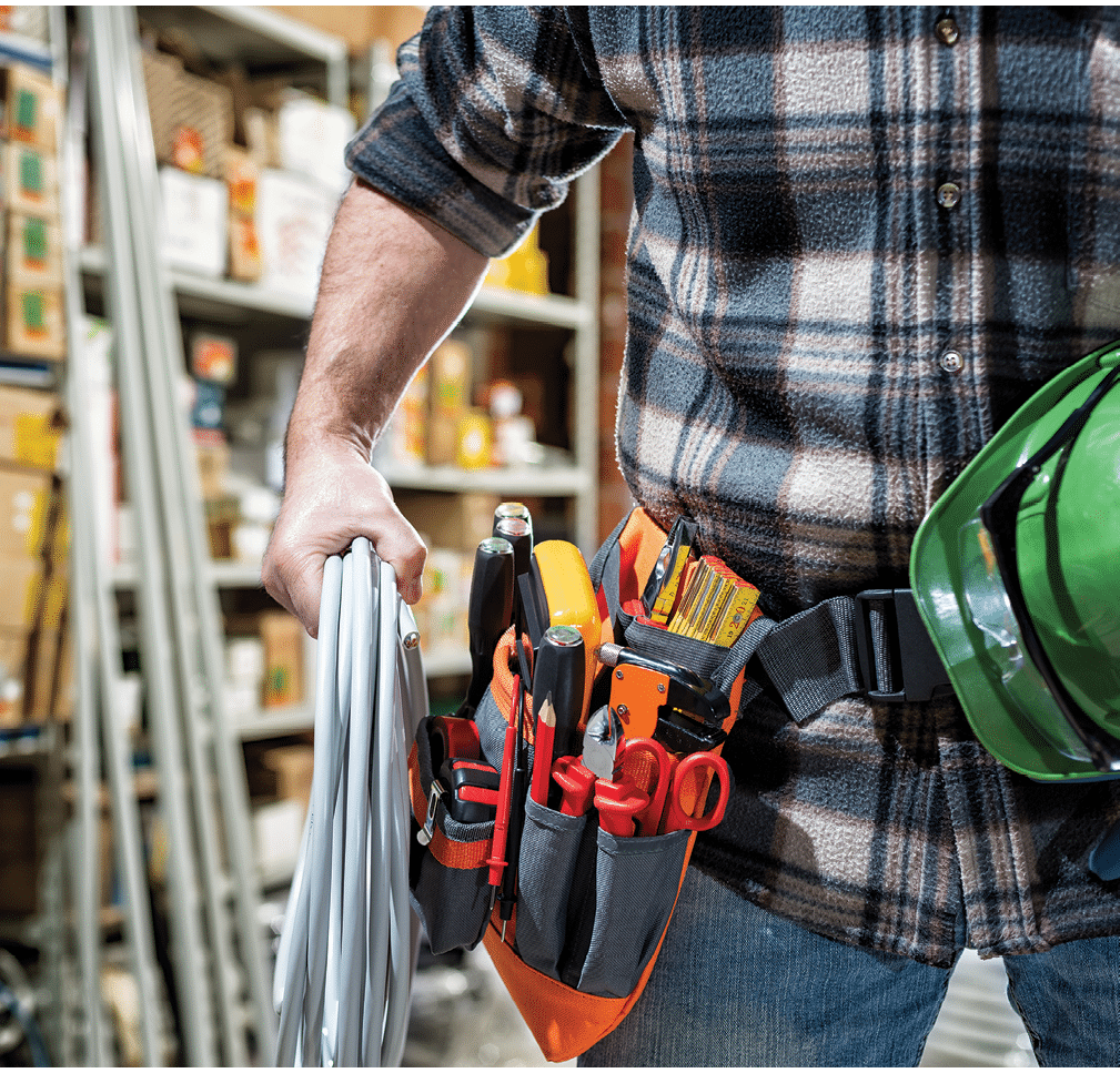 Electrician in the electrical parts store is holding the roll of electrical cable. Construction industry, electrical system.