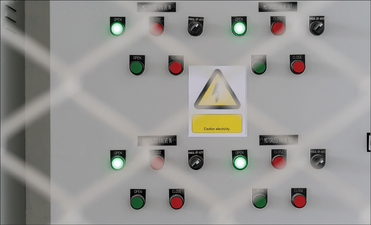 Electric city control panel in grey metal box hanging on wall inside chain link fence cage. electrical panel and cabinet in industrial
