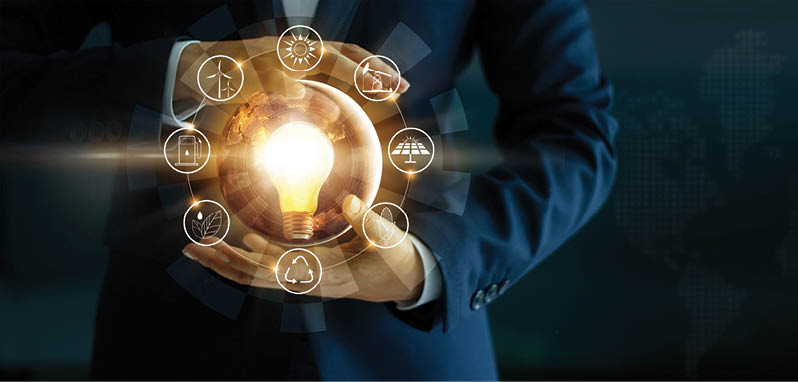 Businessman' s hand holding glowing light bulb with energy sources icon. Campaigning for ecological friendly and sustainable environment. Earth day. Energy saving concept, Elements of this image furnished by NASA