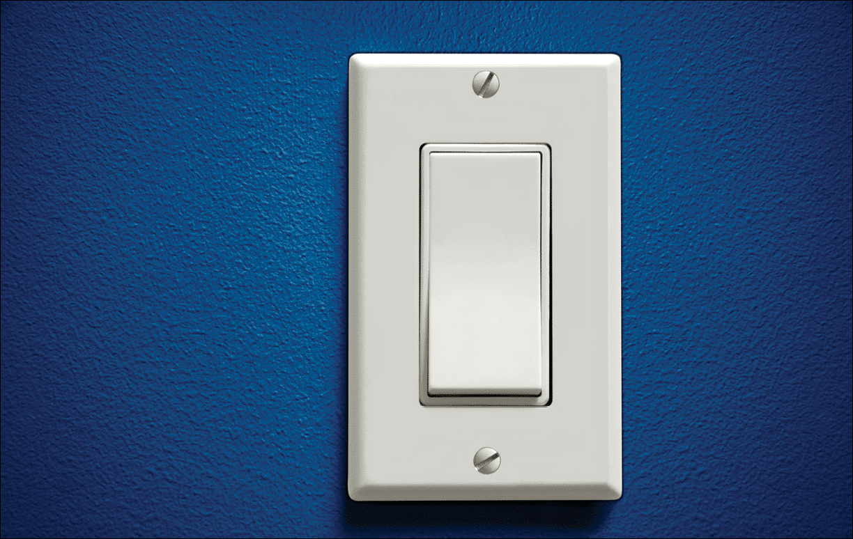 Image of a single light switch on a blue wall