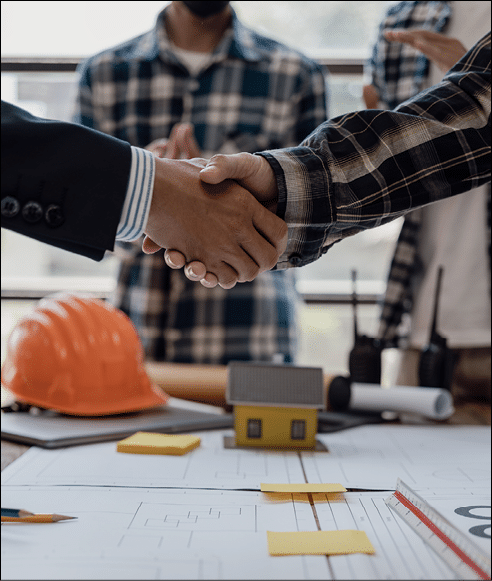 Asian engineer and architect shaking hands After working together to build a successful home and donning a shiny outfit, work on an industry-related construction design project.
