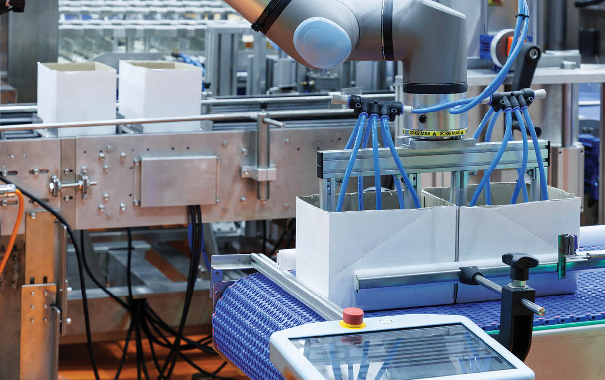 technology automated robotic arm handling product packaging to cardboard boxes on a conveyor belt in modern industrial production line in factory. innovation logistic and production line system