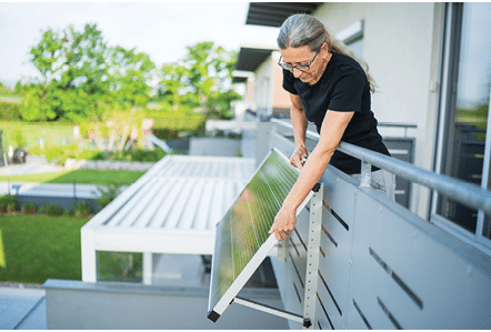 A woman is holding a solar panel. Description generated by AI
