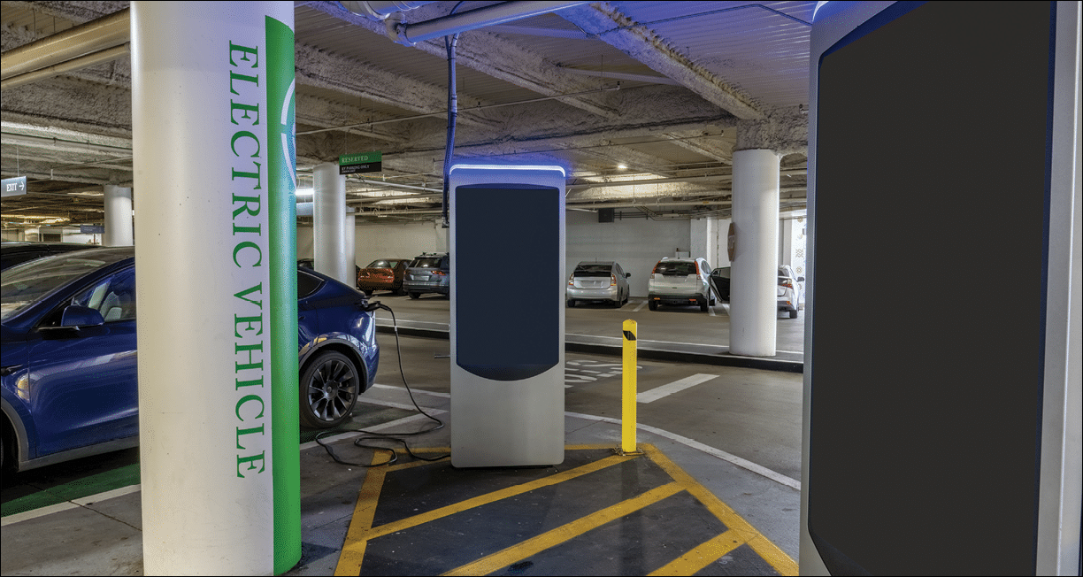 Electric vehicle charging station at parking structure has one car charging and one open stall for renewable energy.